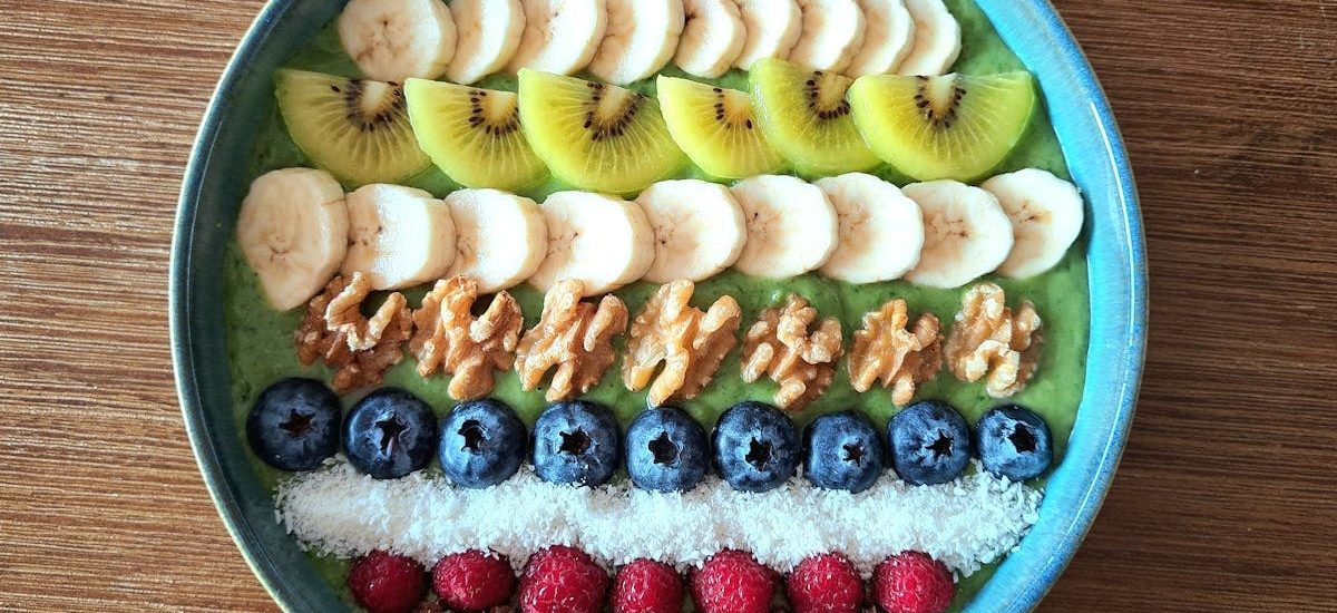 Vibrant smoothie bowl topped with assorted fruits, walnuts, and seeds, perfect for a healthy start.