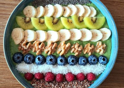 Vibrant smoothie bowl topped with assorted fruits, walnuts, and seeds, perfect for a healthy start.